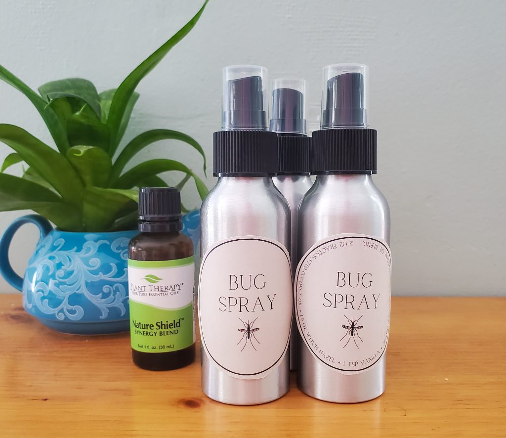 three 4 oz aluminum spray bottles pictured with a plant and an essential oils bottle