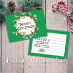 festive pinecones and evergreens with two wrapped candy canes make a backdrop for a green wreathed christmas card reading "I prayed a rosary for you" inside