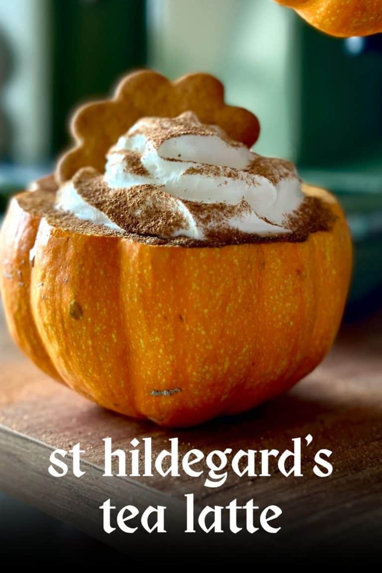 A delicious pumpkin spice chai latte presented inside a carved pumpkin, topped with whipped cream and cocoa powder for seasonal warmth.